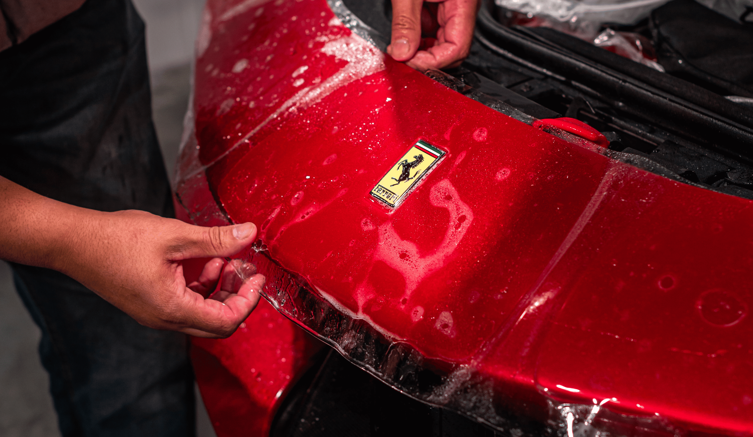 Ferrari close-up showing clear paint protection film applied smoothly